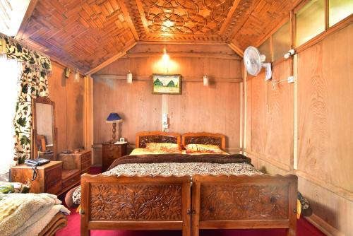 - une chambre avec un lit et un plafond en bois dans l'établissement Houseboat Zaindari Palace, à Srinagar