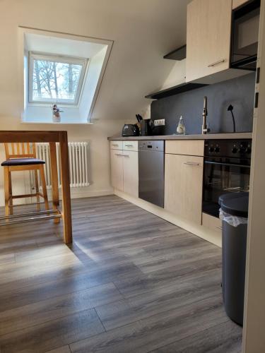 a kitchen with wooden floors and a table and a window at Ferienwohnung Prinzenpalais in Schleswig