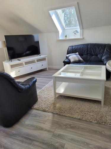 sala de estar con sofá y TV en Ferienwohnung Prinzenpalais, en Schleswig