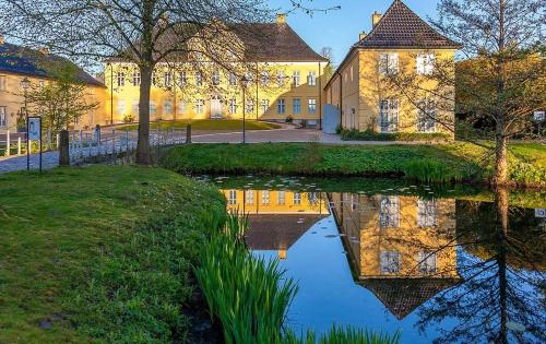 a house with a pond in front of a building at Ferienwohnung Prinzenpalais in Schleswig