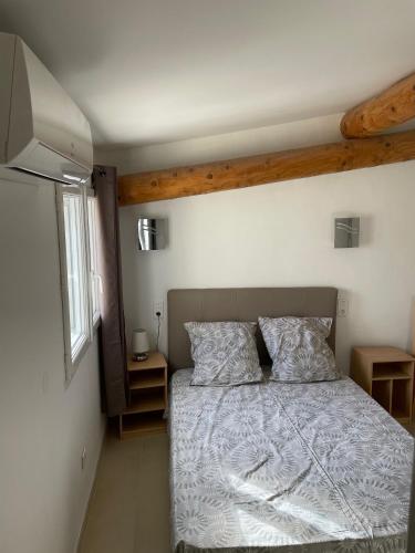 une chambre avec un lit avec une couette blanche dans l'établissement LA FOURNACHE, à Mirabel-aux-Baronnies