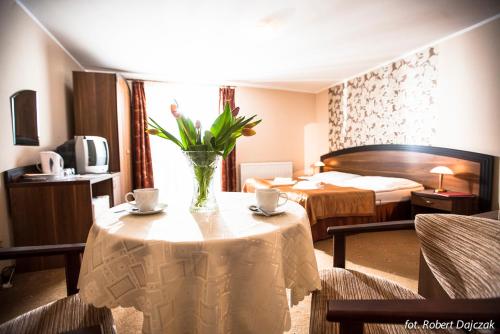 pokój hotelowy ze stołem z wazonem kwiatów w obiekcie Willa Jan w Rewalu