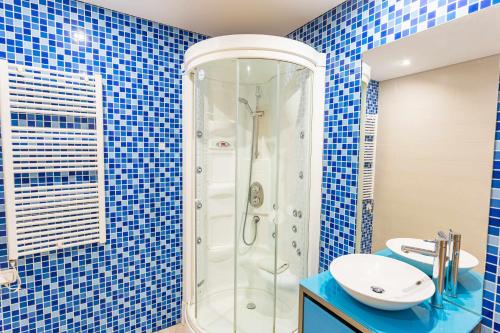 ヴィラモウラにあるMarina Vilamoura Aquamar 013 By VilamouraSunの青いタイル張りのバスルーム(シャワー、シンク付)