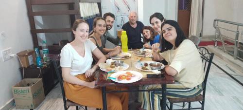 a group of people sitting at a table eating food at Karma Hostel in Khajurāho