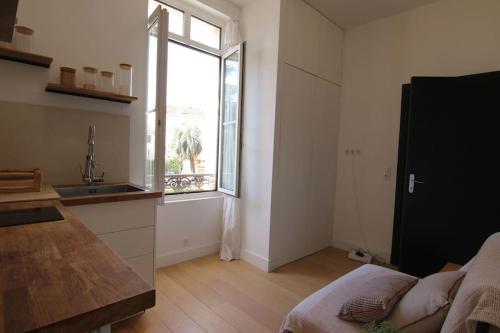 une cuisine avec un évier et une grande fenêtre dans l'établissement Pearl Studio by Halldis, à Cannes