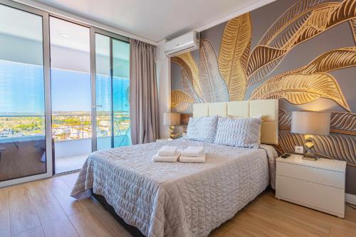 een slaapkamer met een bed en een groot raam bij Marina View Apartment By VilamouraSun in Vilamoura