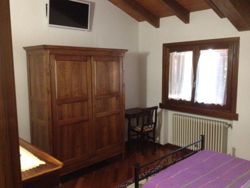 a bedroom with a bed and a cabinet and a window at B&B Simona in Sorbolo
