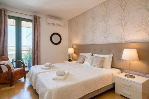 a bedroom with a large bed with two towels on it at Marina Vilamoura - Aquamar 401- Modern Apartment in Vilamoura
