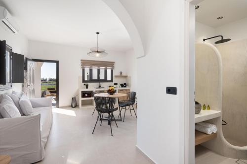 cocina y sala de estar con mesa y sillas en Almira Luxury Suites, en Perivolos