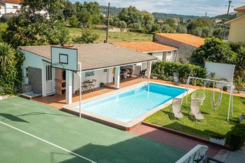 a house with a swimming pool and a basketball hoop at Delfim e Carmo - Entire House com Piscina in São Pedro do Sul