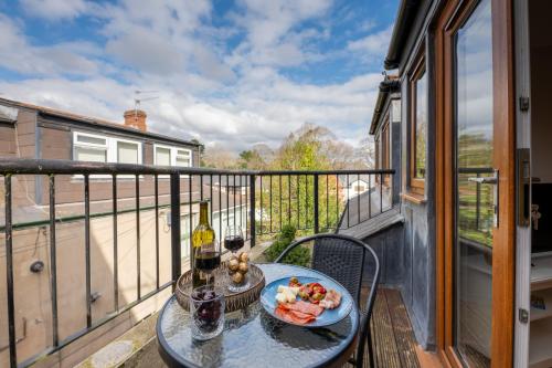 a table with a plate of food and wine on a balcony at 2 Bed Apartment - Cardiff City Centre - Free Parking in Cardiff