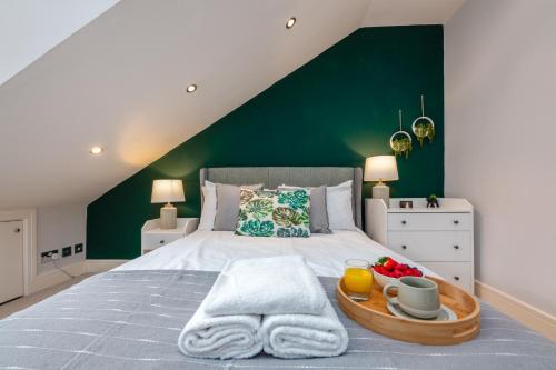 a bedroom with a large bed with a green wall at 2 Bed Apartment - Cardiff City Centre - Free Parking in Cardiff