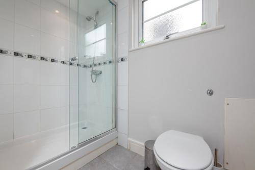 a bathroom with a toilet and a glass shower at 2 Bed Apartment - Cardiff City Centre - Free Parking in Cardiff