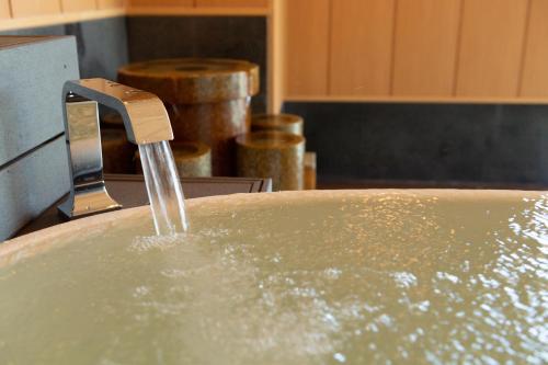 a sink with water coming out of a faucet at Hotel Oyanagi in Tagami