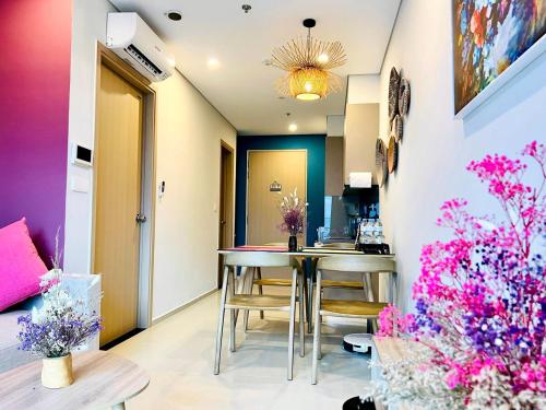 a dining room with a table and some flowers at The Sóng Vũng Tàu - Mochi House in Vung Tau