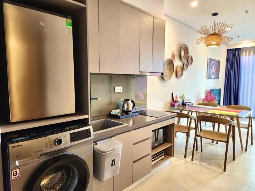 a kitchen with a washing machine and a dining room at The Sóng Vũng Tàu - Mochi House in Vung Tau