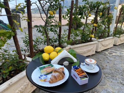 un tavolo con un piatto di cibo e una tazza di caffè di Dint'a Torre Bed and Breakfast a Scala
