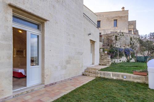 a house with a white door and a yard at L'Antica Conceria in Matera