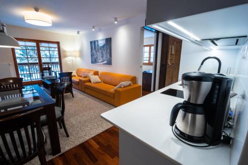 una cucina e un soggiorno con una macchinetta del caffè su un bancone di Apartamenty Lola a Szklarska Poręba