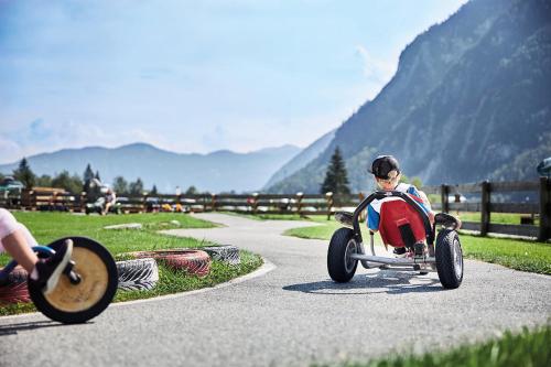 a little boy riding a toy car on a road at Familienresort Buchau in Maurach