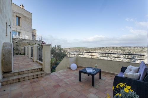 a patio with a couch and a table on a balcony at L'Antica Conceria in Matera