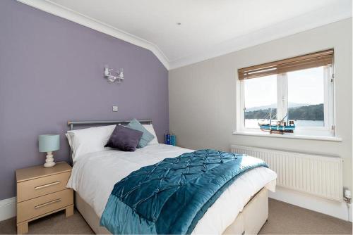 Un dormitorio con una cama y una ventana con un barco. en Walton House en Conwy