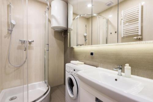 a bathroom with a sink and a washing machine at Luxury Apartments Nearto Main Square in Krakow