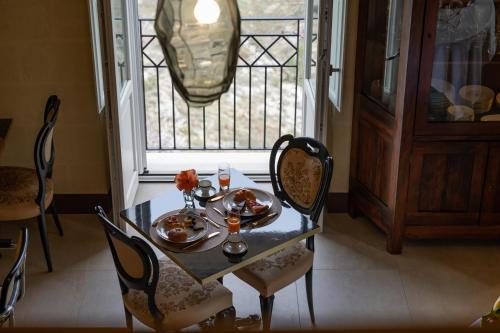 a table with plates of food on it in front of a window at L'Antica Conceria in Matera