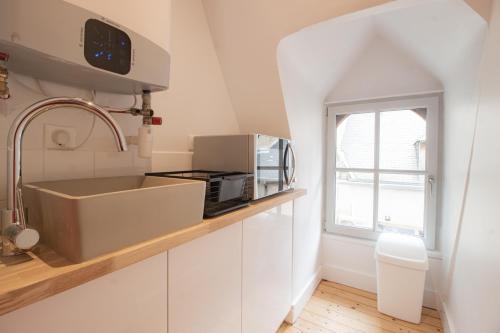 a white kitchen with a sink and a microwave at LE COURSARLON in Bourges