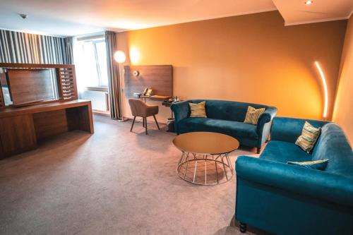 una sala de estar con 2 sofás azules y una mesa. en Steinberger Hof, en Dietzenbach
