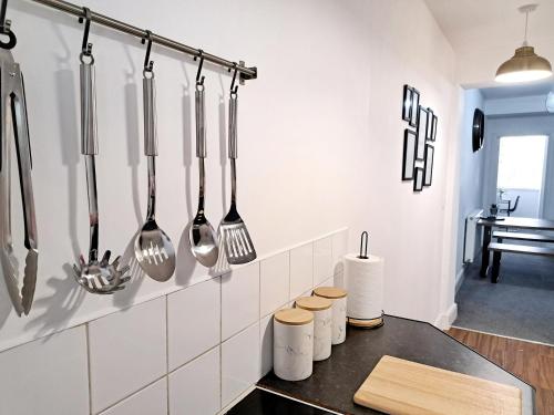 a kitchen with utensils hanging on a wall at STYLISH 2 Bed APARTMENT WITH FREE PARKING, WIFI in Colchester