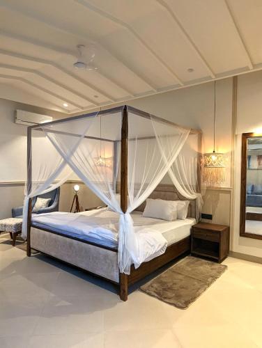 sypialnia z dużym łóżkiem z baldachimem w obiekcie Cape House - Presidential Suite w mieście Amritsar