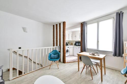 un salon avec une table et des chaises et un escalier dans l'établissement Séguier proche Seine, à Paris