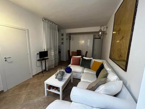 a living room with a white couch and a table at Rose in Tirrenia
