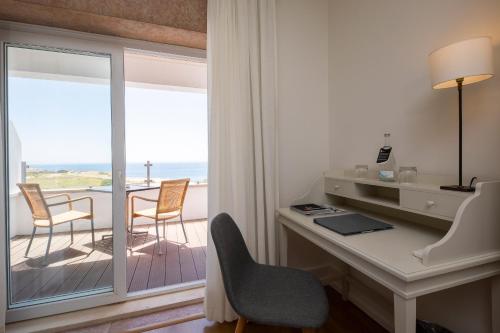 a room with a desk and a view of the ocean at Pousada de Sagres in Sagres