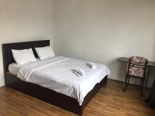 Una cama con dos toallas blancas encima. en Guest Apartment en Ganja