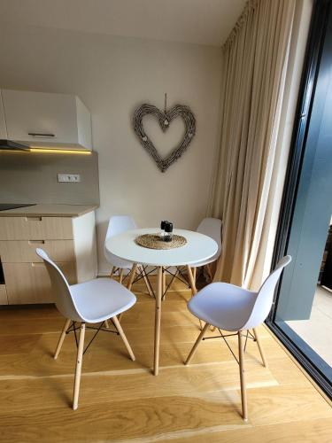 a dining room with a table and chairs and a heart sign at Molo Lipno in Lipno nad Vltavou
