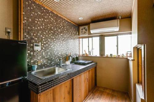 a kitchen with a sink and a brick wall at TSUDOYA 天王寺 in Osaka