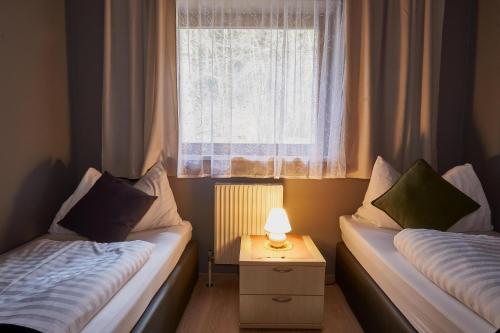 two beds in a small room with a window at The Art and Sporthotel in Innsbruck