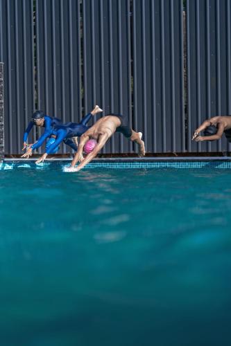 a group of people swimming in a swimming pool at Anamala Serenity Homestay Kerala in Lakkidi