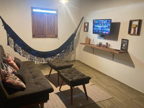 a living room with a couch and a flat screen tv at Chalés Samambaia in Bananeiras