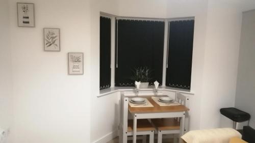 a small table in a room with two windows at Immaculate 1-Bed Apartment in Hinckley in Hinckley