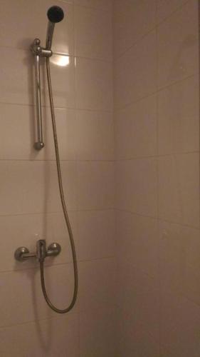 een douche met een douchekop in de badkamer bij Chambre Privee Salle de Bain Privee centre ville Claye in Claye-Souilly