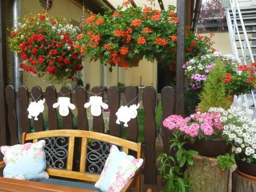 a wooden bench sitting in front of a fence with flowers at Gasthaus Forelle in Thale