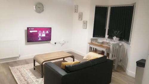 a living room with a couch and a tv at Immaculate 1-Bed Apartment in Hinckley in Hinckley
