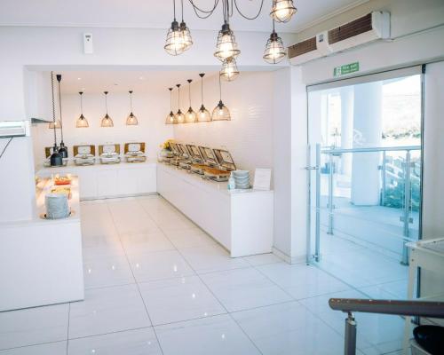 a store with white walls and pendant lights at Filoxenia Hotel Zakynthos in Tsilivi