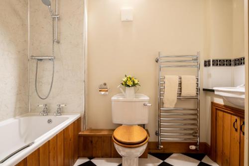 a bathroom with a toilet and a tub and a sink at Garden Cottage at Eaton Manor in Eaton