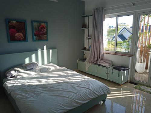 a bedroom with a bed and a large window at 29-House in Cà Mau
