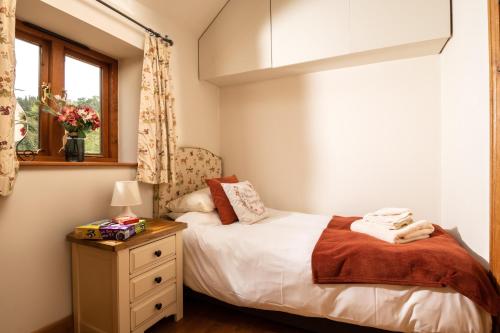 a small bedroom with a bed and a window at Garden Cottage at Eaton Manor in Eaton