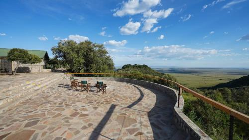 a patio with tables and chairs on top of a hill at Mara Elatia Camp in Masai Mara